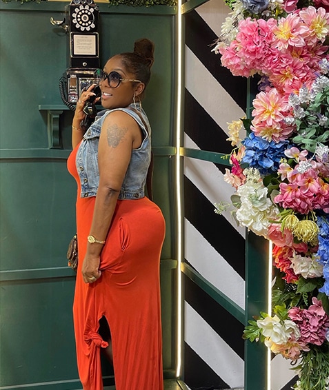 woman standing near a phone and flowers